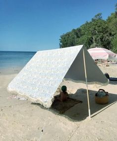 a white tent sitting on top of a sandy beach