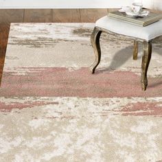 a white rug with pink and beige designs on it in a living room area next to a chair