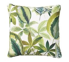 a green and white pillow with leaves on it