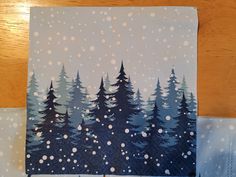 a piece of paper with trees painted on it and snow falling off the tree tops