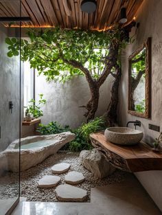 a bathroom with a tree in the corner and two sinks on the counter, surrounded by rocks