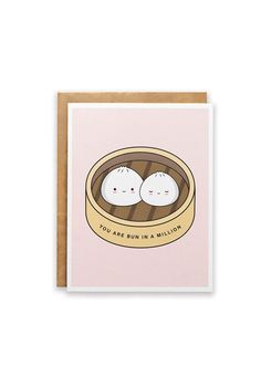 a pink card with two little white buns in a wooden container