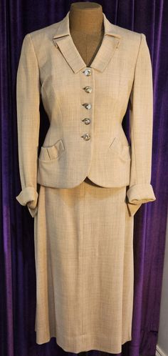 This beautiful 1940s suit is in excellent vintage condition.  There is a soft shoulder pad on each side.  The side zipper has been replaced with a nylon one that matches the pink blush color of the suit exactly.  Closure is via the 5  3/4" exquisite frosted white and bronze buttons - each with a rhinestone in its center.   Please be sure to note the fold in the center of each of the 6" curved pouch pockets at each hip; this same fold is featured on the 2" wide collar.  There is a 6" kick pleat in the back of the skirt.  The jacket is lined in a clay color satin.  Each sleeve features a 2" open cuff. Approximate measurements:      jacket shoulder to shoulder:  15" arm pit to arm pit:  18" waist:  28" hips:  33" back length:  24" sleeve length:  22"     skirt waist:  24" hips:  34" skirt len Classic Skirt Suit With Notch Lapel, Classic Skirt Suit With Buttons For Formal Occasions, Classic Formal Skirt Suit With Buttons, Vintage Fitted Skirt Suit For Formal Occasions, Elegant Fitted Lined Skirt Suit, Elegant Formal Lined Blazer, Vintage Lined Skirt Suit For Formal Occasions, Vintage Single Button Suit For Semi-formal Occasions, Tailored Classic Skirt Suit