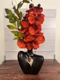 a vase with red flowers in it sitting on a table