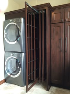 a washer and dryer sitting next to each other in front of wooden cabinets