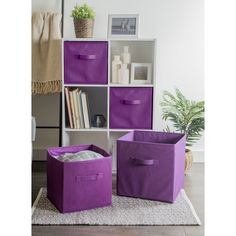 two purple storage bins sitting on top of a rug next to a book shelf