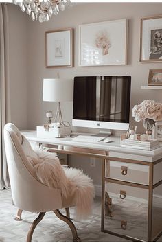 a desk with a computer, chair and pictures on the wall