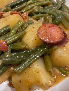 a white plate topped with green beans and potatoes