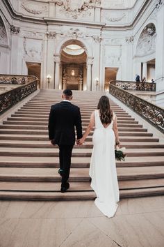 a bride and groom walking down the stairs at their wedding ceremony in san francisco, california