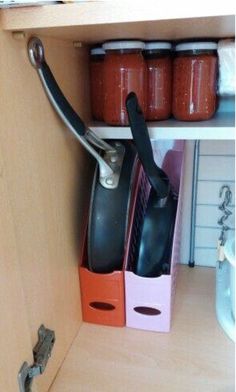 the kitchen cabinet is organized with utensils and other cooking supplies, including pots and pans