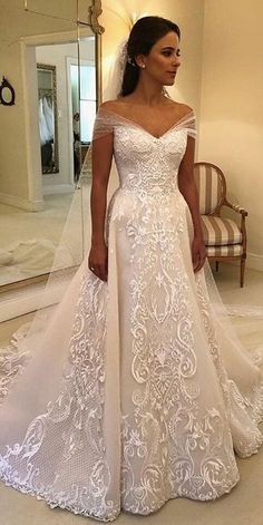 a woman in a white wedding dress standing in front of a mirror