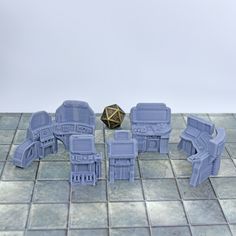 some blue plastic toys sitting on top of a tile floor next to a golden object