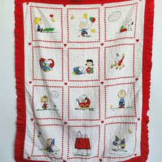 a red and white wall hanging with peanuts on it's sides, featuring images of characters