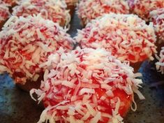 several cupcakes covered in red and white coconut sprinkled with icing