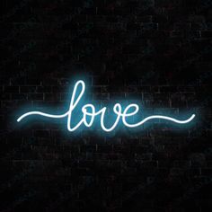 a neon sign that says love on a brick wall