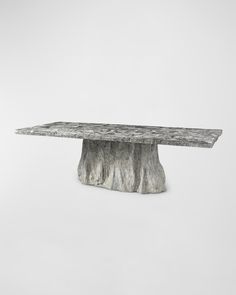 a table made out of concrete with a tree stump like base on the top and bottom