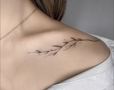 the back of a woman's shoulder with an arrow tattoo