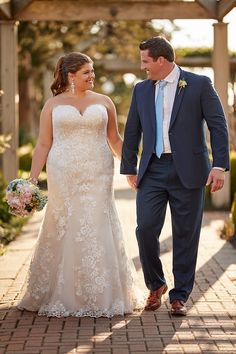 a bride and groom walking down the sidewalk