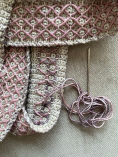 a close up of a knitted scarf and knitting needles