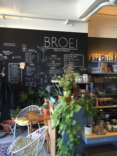 the interior of a coffee shop with plants and potted plants