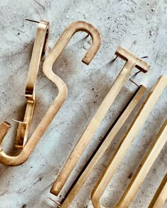 three pieces of wood sitting next to each other on a table with the letters cut out