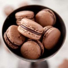 a bowl filled with macaroons sitting on top of a table