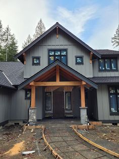 a large gray house with lots of windows and wood trimmings on the front