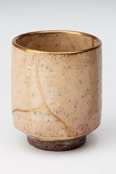 a brown and white vase sitting on top of a table