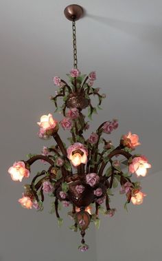 a chandelier with pink flowers hanging from it's center point and two lights on each side