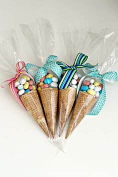 three ice cream cones wrapped in cellophane with candy