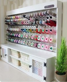 a white shelf filled with lots of different colored thread