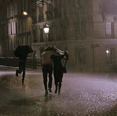 two people walking in the rain with umbrellas