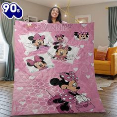 a woman holding up a minnie mouse blanket