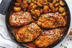 chicken and potatoes in a skillet with parsley on the side, ready to be eaten