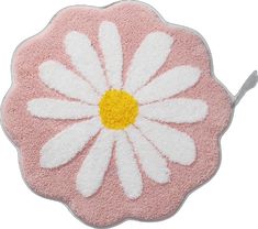 a pink and white rug with a flower on the front, it has a yellow center