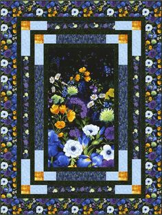 a blue and yellow quilt with flowers on it's border, in the center