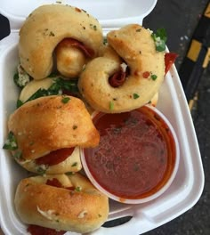 a takeout container filled with sandwiches and dipping sauce