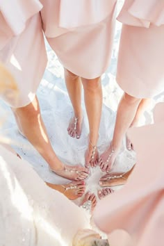 four bridesmaids standing in a circle with their feet together