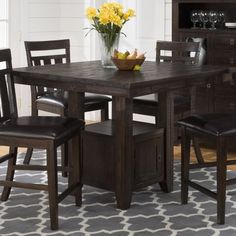 a dining room table with four chairs around it