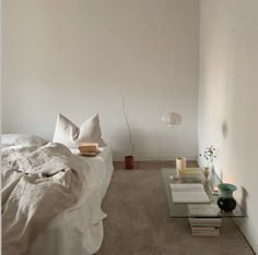 a bed with white sheets and pillows in a room