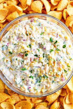 a glass bowl filled with corn salad and chips