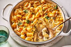 a casserole dish with pasta and spinach in it next to a bowl of soup