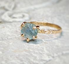 a close up of a ring with a stone in the middle on a rock surface