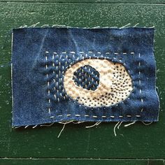 a piece of denim with a hole in the middle and stitching at the bottom