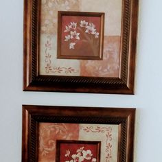 two framed pictures hanging on the wall next to each other with flowers painted on them