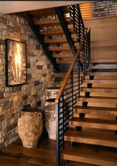 there is a stone wall and stairs in this house with wood flooring on both sides