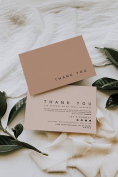 two thank you cards sitting on top of each other next to some green plants and leaves