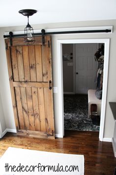 an open door in a room with wood floors and white walls, next to a rug on the floor