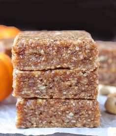 three pieces of granola bars stacked on top of each other next to oranges