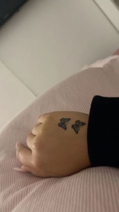 a person with a tattoo on their arm laying in bed